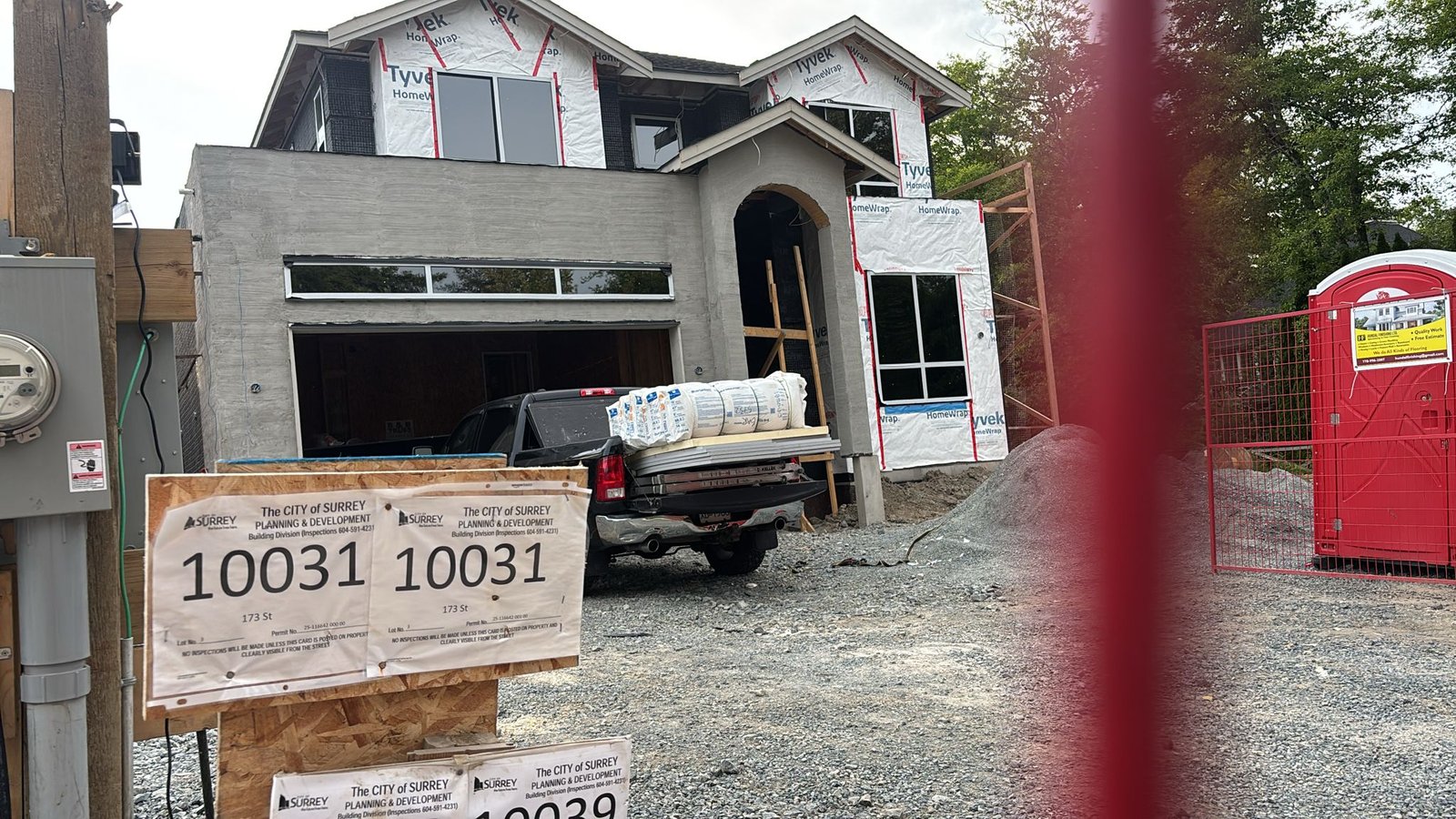 New-build home exterior with permit boards on a Surrey insulation project