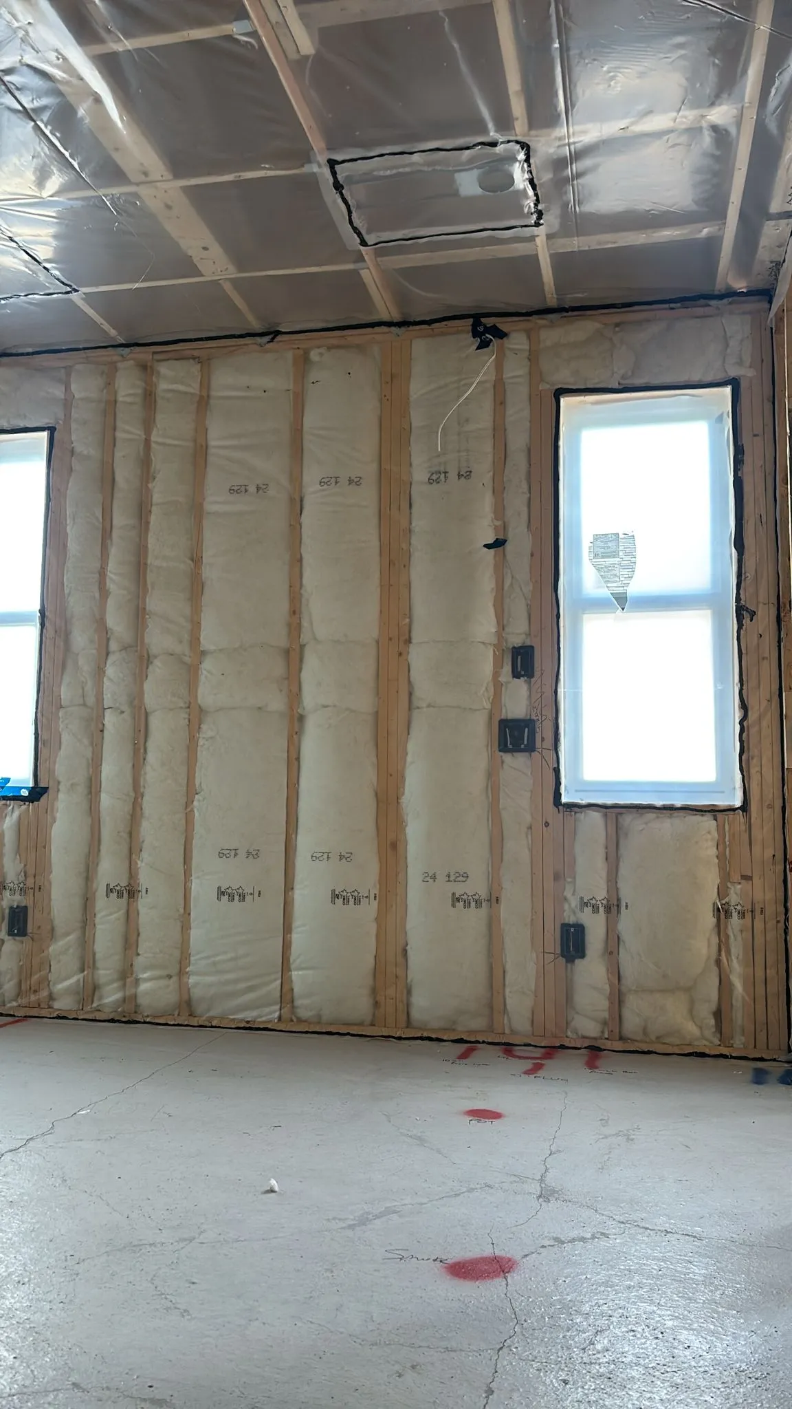 Fibreglass batt insulation installed across wall cavities